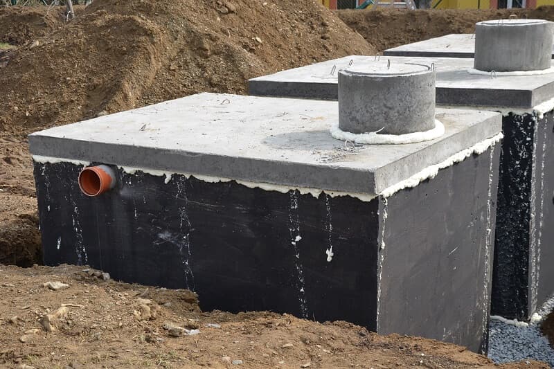 rząd zbiorników betonowych połączonych rurą